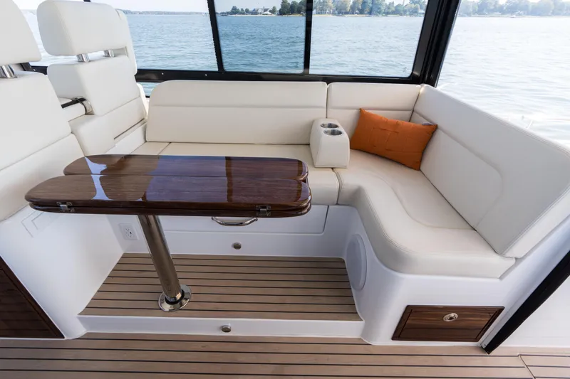 Middle Path Yacht Photos Pics Luxurious seating area on 2023 MJM Yachts 4, featuring elegant wood table and scenic water view.