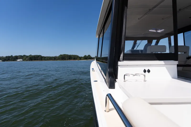 Middle Path Yacht Photos Pics 2023 MJM Yachts 4 cruising on a serene lake under a clear blue sky.