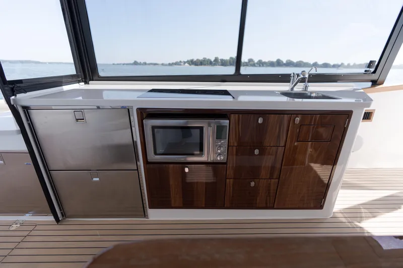 Middle Path Yacht Photos Pics Modern galley kitchen on 2023 MJM Yachts 4, featuring sleek cabinetry and appliances.