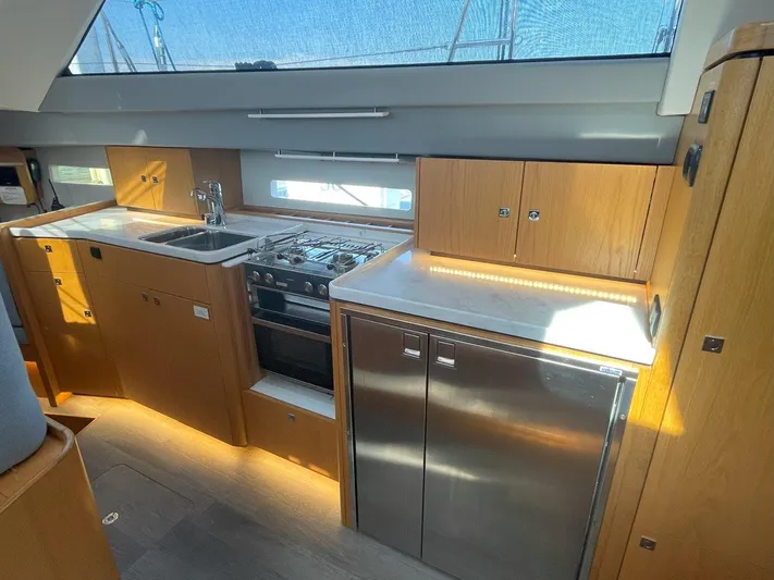 Off The Grid Yacht Photos Pics Modern kitchen interior of 2024 Southerly 420 yacht with wood cabinetry and stainless steel appliances.