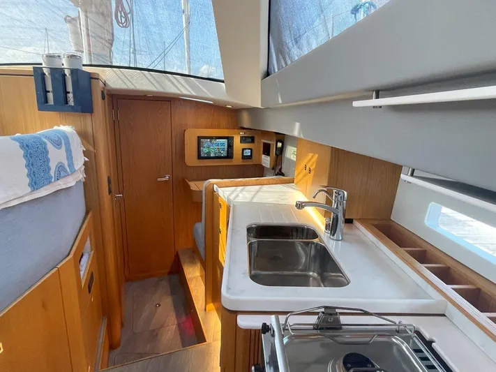 Off The Grid Yacht Photos Pics Modern interior of 2024 Southerly 420 yacht, featuring sleek kitchen and wooden cabinetry.
