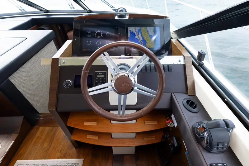 Salty Sam Yacht Photos Pics Steering wheel and dashboard of 2014 Tiara 5000 Coupe yacht with navigation display.