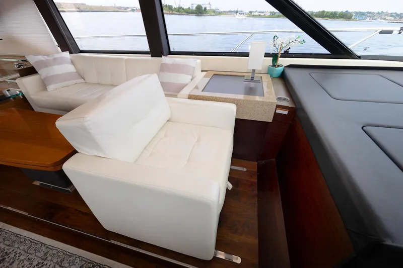 Salty Sam Yacht Photos Pics Luxurious interior of 2014 Tiara 5000 Coupe yacht with white seating and wooden accents.