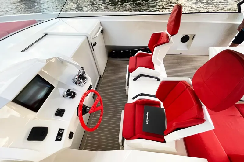  Yacht Photos Pics Interior of 2016 Vanquish Yachts 48 with red seats and modern helm controls.