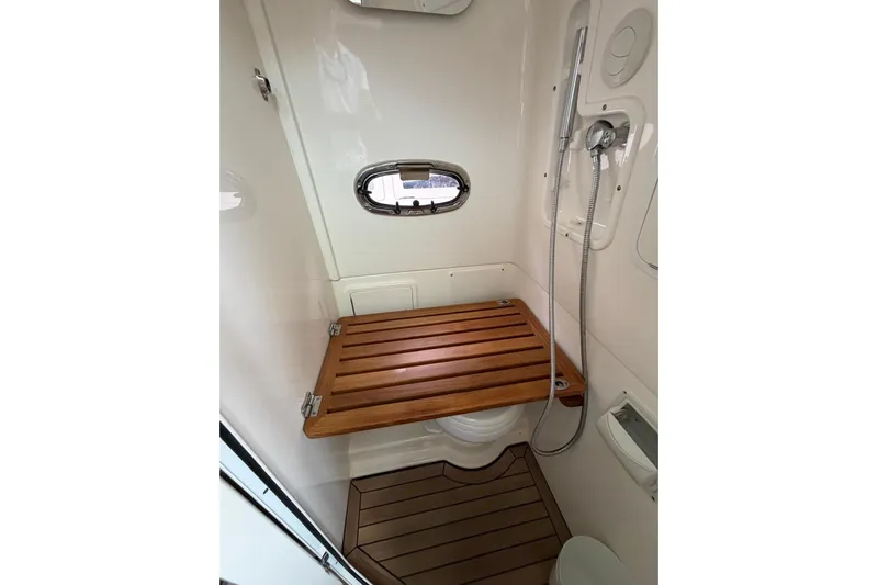  Yacht Photos Pics 2022 Boston Whaler 380 Outrage bathroom with wooden seat and showerhead.