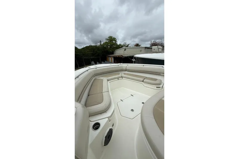 Yacht Photos Pics 2022 Boston Whaler 380 Outrage boat interior with cushioned seating under cloudy sky.