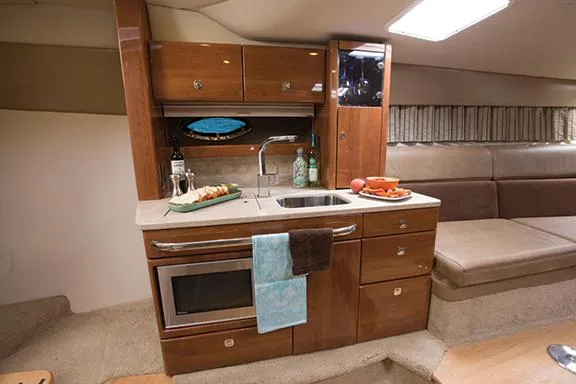 Wet Benefits Yacht Photos Pics Manufacturer Provided Image: 2015 Formula 370 Super Sport yacht interior kitchen with sink, microwave, and seating area.