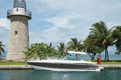 Wet Benefits Yacht Photos Pics Manufacturer Provided Image: 2015 Formula 370 Super Sport boat near a lighthouse and palm trees.