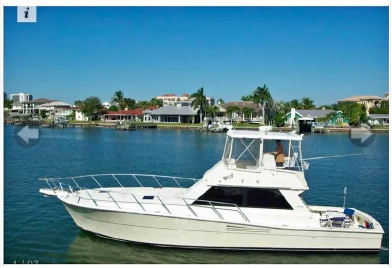 Double Deese Yacht Photos Pics 1989 Viking fish boat on calm water with scenic waterfront background.