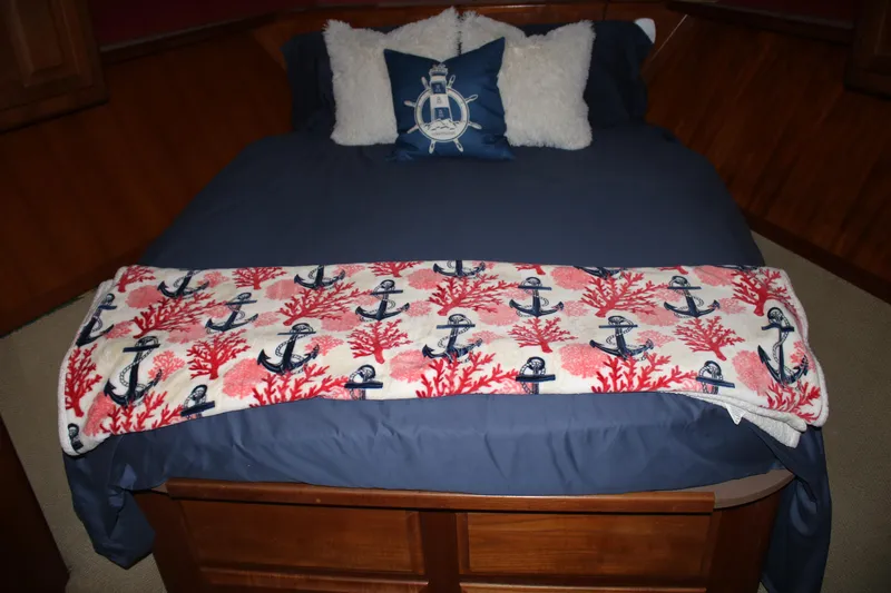 Double Deese Yacht Photos Pics Nautical-themed bed with anchor-patterned blanket on a 1989 Viking Fish model.