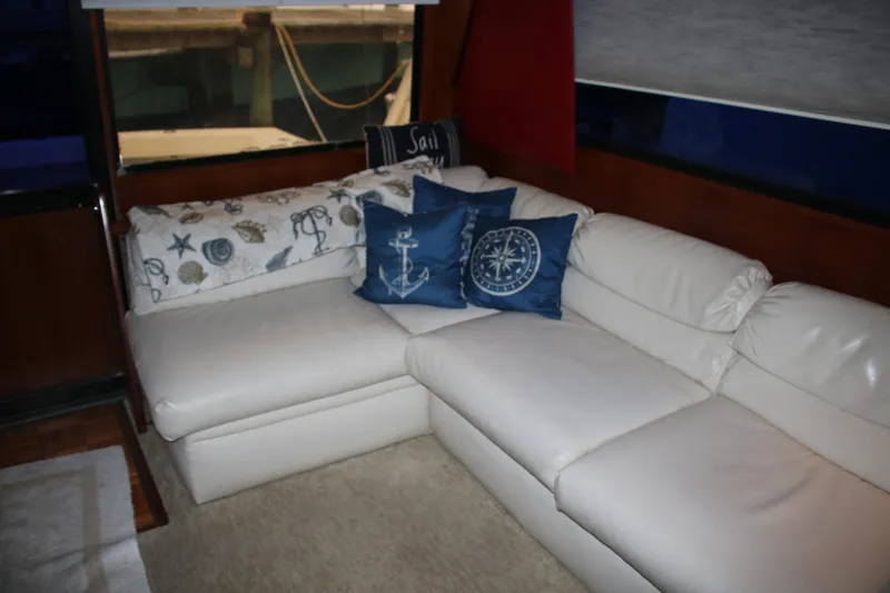 Double Deese Yacht Photos Pics Luxurious 1989 Viking fish boat interior with white leather seating and nautical-themed cushions.