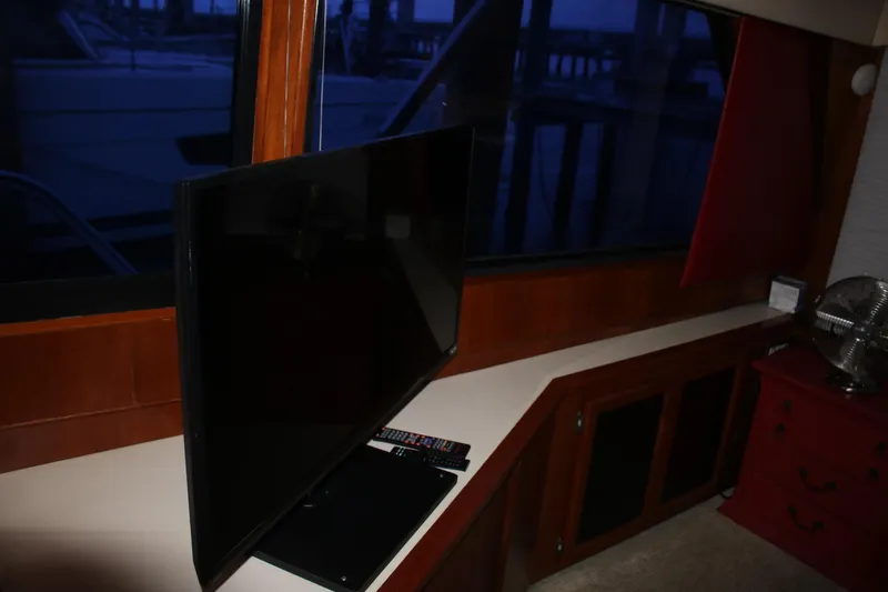 Double Deese Yacht Photos Pics Interior of a 1989 Viking fish boat with a TV and remote on a wooden counter.