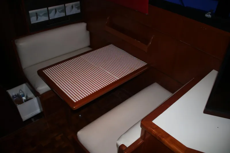Double Deese Yacht Photos Pics 1989 Viking fish boat interior with striped table and cushioned seating.