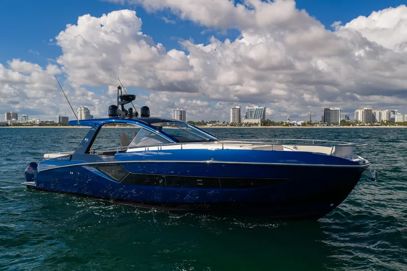  Yacht Photos Pics 2022 Azimut Verve 47 yacht cruising on a sunny day with city skyline backdrop.
