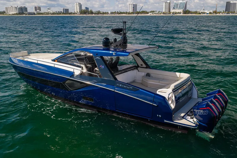  Yacht Photos Pics 2022 Azimut Verve 47 luxury yacht cruising on open water, city skyline in background.