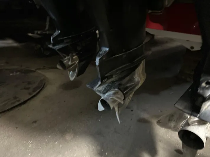  Yacht Photos Pics Propellers of a 2007 Donzi 38 ZF Cuddy boat in a dimly lit setting.