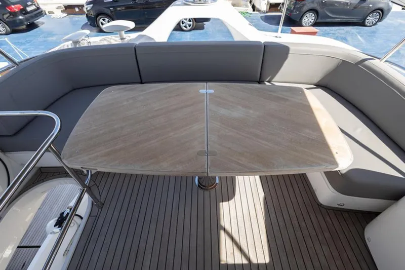  Yacht Photos Pics Luxurious seating area on 2021 Princess F45 yacht with wooden table and cushioned benches.