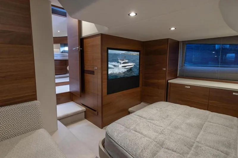  Yacht Photos Pics Luxurious interior of 2021 Princess F45 yacht with modern wood finishes and cozy bedding.