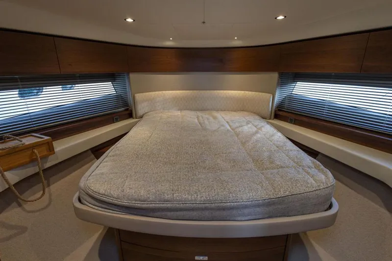  Yacht Photos Pics Luxurious cabin interior of 2021 Princess F45 yacht with cozy bed and elegant wood finishes.