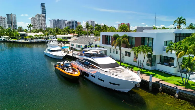  Yacht Photos Pics Luxury yachts docked by modern waterfront homes, featuring a 2022 Midnight Express 43 Open.