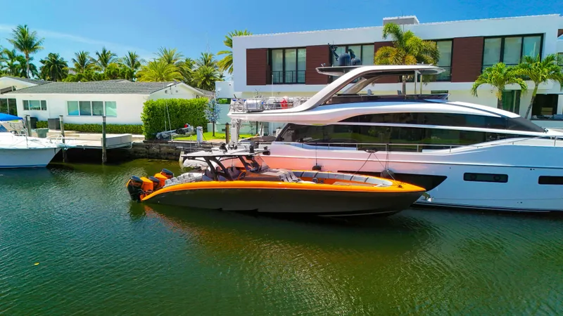  Yacht Photos Pics 2022 Midnight Express 43 Open boat docked beside a luxury yacht in a sunny marina.