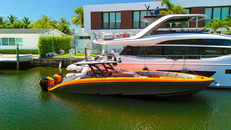  Yacht Photos Pics 2022 Midnight Express 43 Open boat docked beside a luxury yacht in a sunny marina.