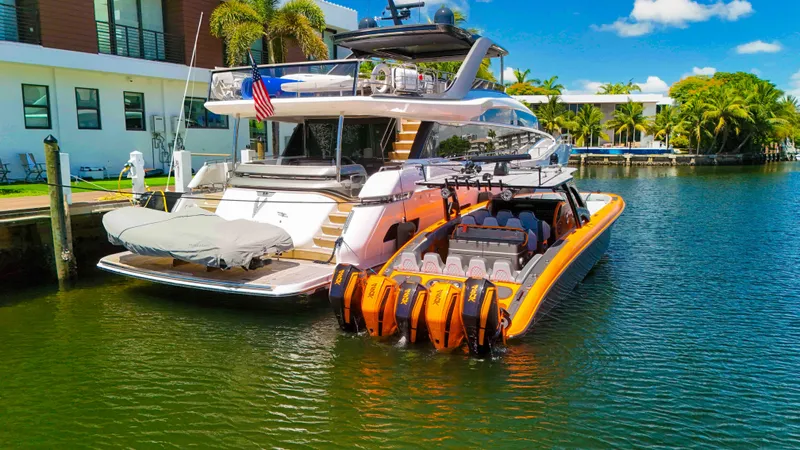  Yacht Photos Pics Luxury yacht docked with a 2022 Midnight Express 43 Open boat, featuring vibrant orange accents.