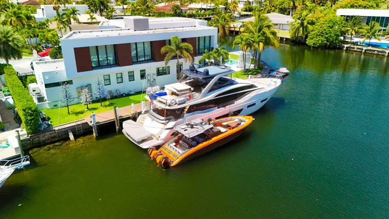  Yacht Photos Pics Luxury yacht docked beside modern waterfront home, featuring a 2022 Midnight Express 43 Open.