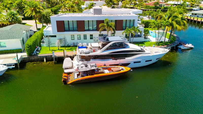  Yacht Photos Pics Luxury yacht and 2022 Midnight Express 43 Open docked by modern waterfront home.