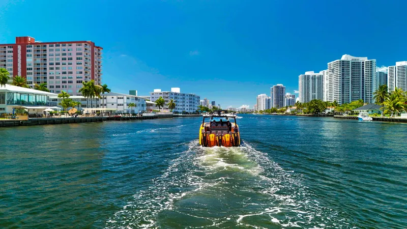  Yacht Photos Pics Midnight Express 43 Open boat cruising in a city waterway, surrounded by modern buildings.