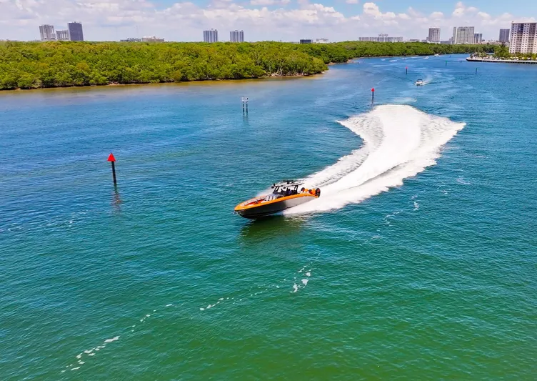  Yacht Photos Pics 2022 Midnight Express 43 Open speeding on a scenic waterway with city skyline backdrop.