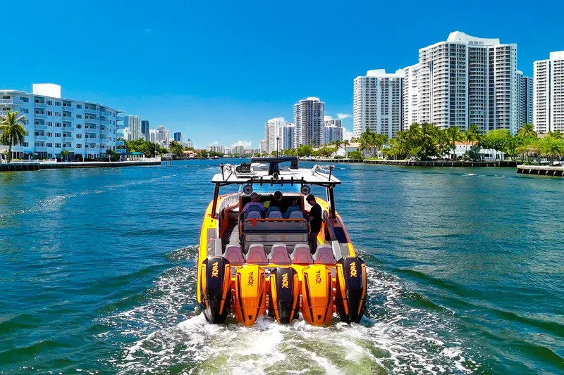  Yacht Photos Pics 2022 Midnight Express 43 Open boat cruising in a city waterway with skyscrapers.