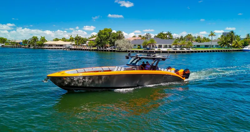  Yacht Photos Pics 2022 Midnight Express 43 Open boat cruising on a sunny day, surrounded by palm trees and waterfront homes.