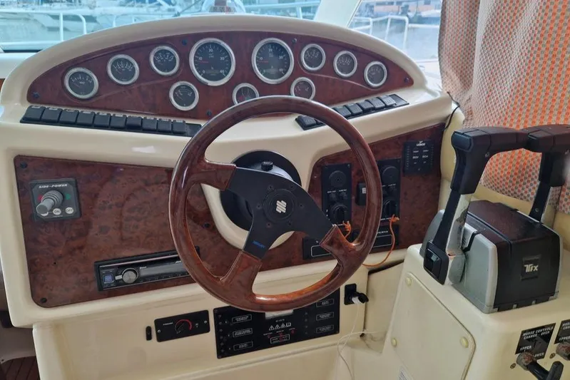  Yacht Photos Pics Helm of 2005 Jeanneau PRESTIGE 32 FLY yacht with wood accents and control panel.