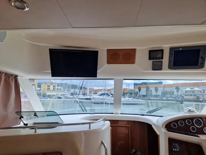  Yacht Photos Pics Interior view of 2005 Jeanneau PRESTIGE 32 FLY yacht with navigation equipment and marina backdrop.