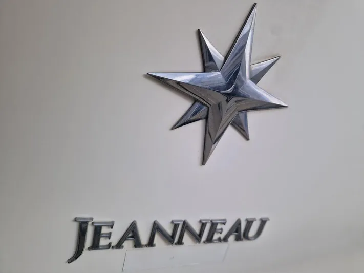  Yacht Photos Pics Jeanneau logo on a 2005 PRESTIGE 32 FLY yacht, featuring a metallic star emblem.