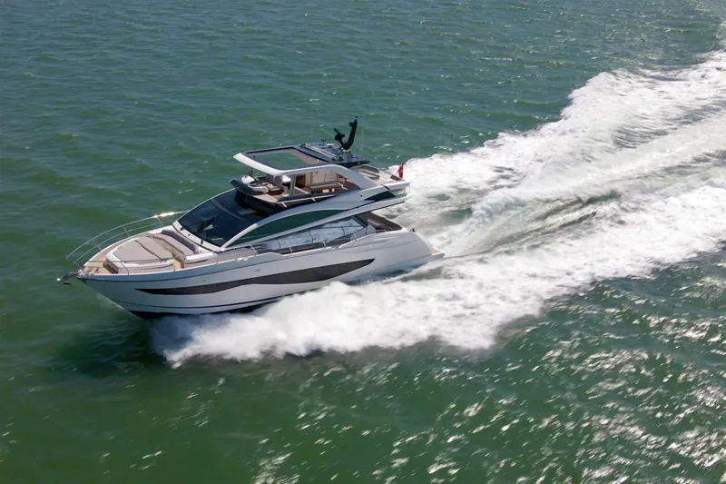 Madness V Yacht Photos Pics Luxurious 2022 Pearl 62 yacht cruising swiftly on open water.