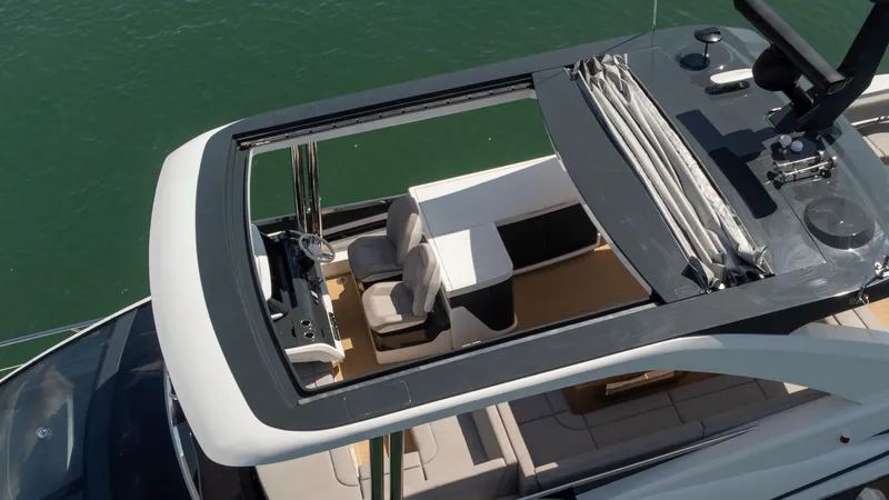 Madness V Yacht Photos Pics Aerial view of 2022 Pearl 62 yacht's open sunroof and seating area.