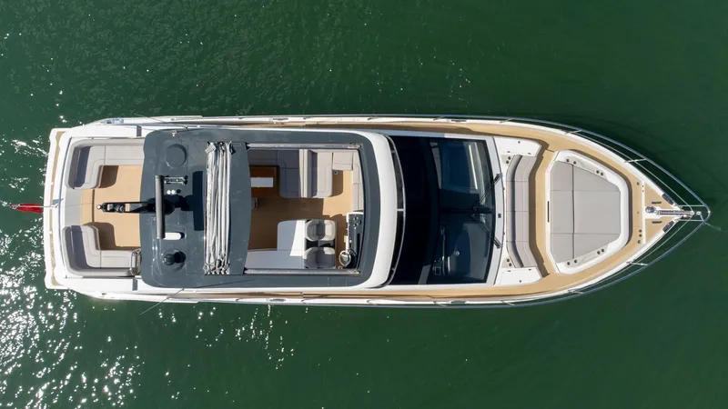 Madness V Yacht Photos Pics Top view of 2022 Pearl 62 yacht on calm green water.
