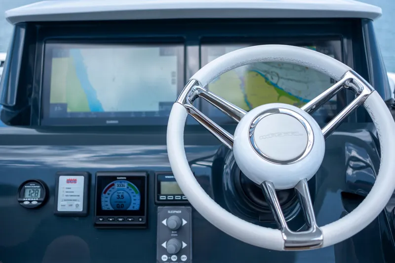 Madness V Yacht Photos Pics Steering wheel and navigation screens on 2022 Pearl 62 yacht dashboard.