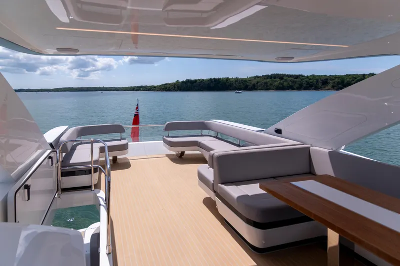 Madness V Yacht Photos Pics Luxurious Pearl 62 yacht deck, 2022 model, with elegant seating and scenic water view.