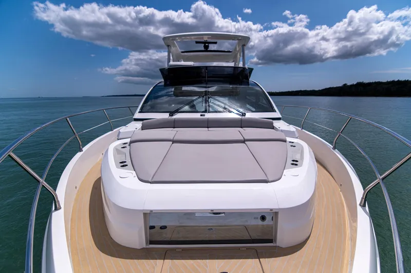 Madness V Yacht Photos Pics Luxury Pearl 62 yacht deck, 2022 model, cruising on calm waters under a blue sky.
