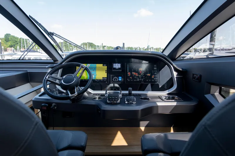 Madness V Yacht Photos Pics Luxurious 2022 Pearl 62 yacht cockpit with advanced navigation system and sleek steering wheel.