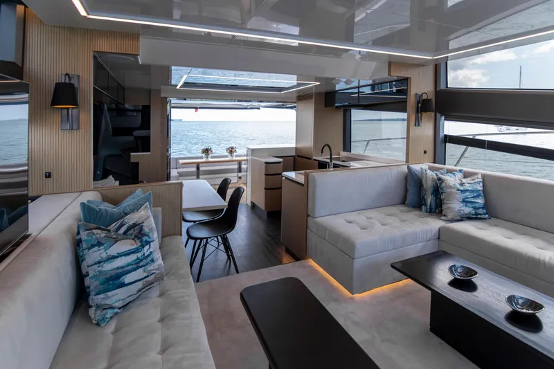 Madness V Yacht Photos Pics Luxurious interior of 2022 Pearl 62 yacht with modern seating and ocean view.