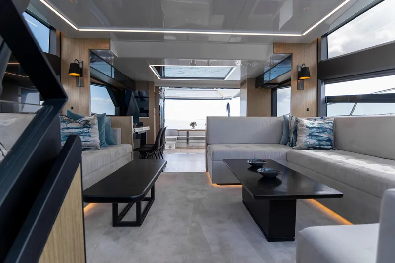 Madness V Yacht Photos Pics Luxurious interior of 2022 Pearl 62 yacht with modern furnishings and panoramic windows.