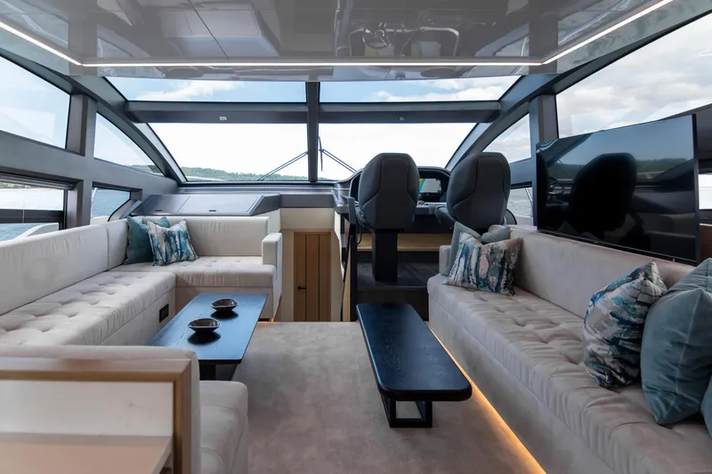 Madness V Yacht Photos Pics Luxurious interior of 2022 Pearl 62 yacht with plush seating and panoramic windows.