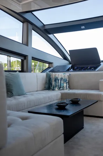 Madness V Yacht Photos Pics Luxurious interior of 2022 Pearl 62 yacht with modern seating and panoramic windows.