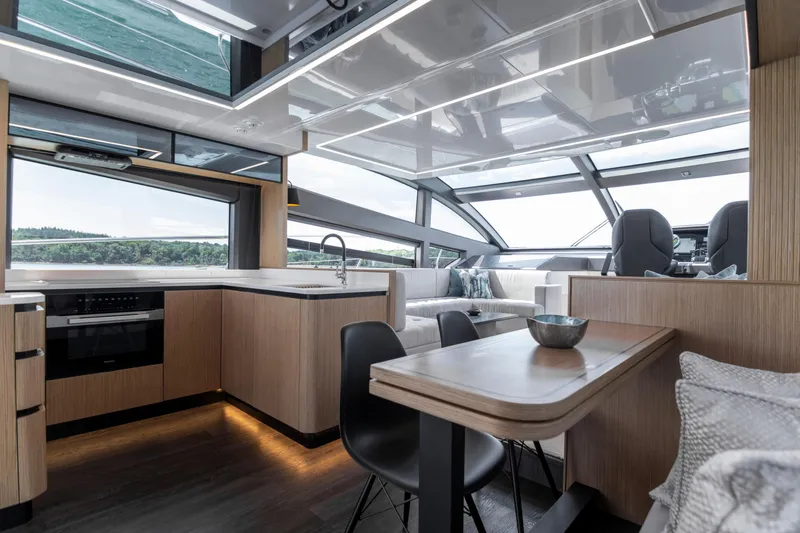 Madness V Yacht Photos Pics Luxurious interior of 2022 Pearl 62 yacht with modern kitchen and dining area.