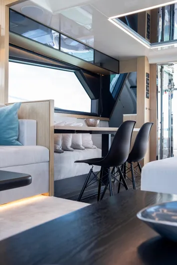 Madness V Yacht Photos Pics Luxurious interior of 2022 Pearl 62 yacht with modern dining area and sleek design.