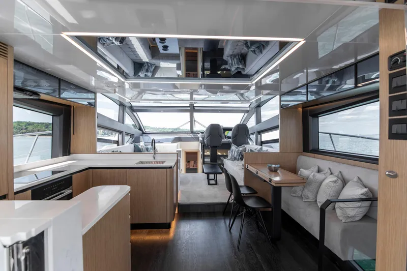 Madness V Yacht Photos Pics Luxurious interior of 2022 Pearl 62 yacht with modern kitchen and seating area.